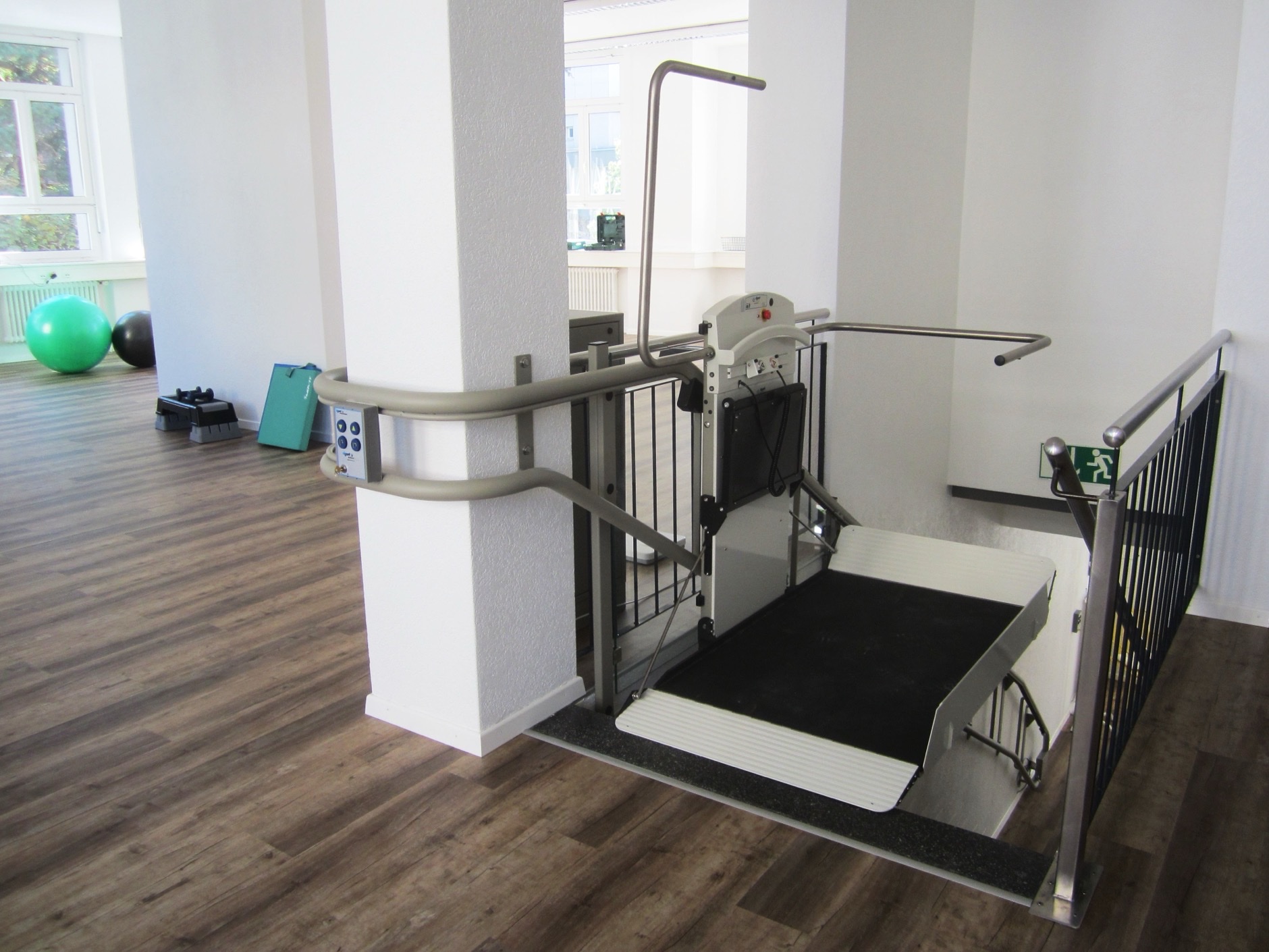 Physical therapy clinic gym area with exercise equipment and accessible mobility lift