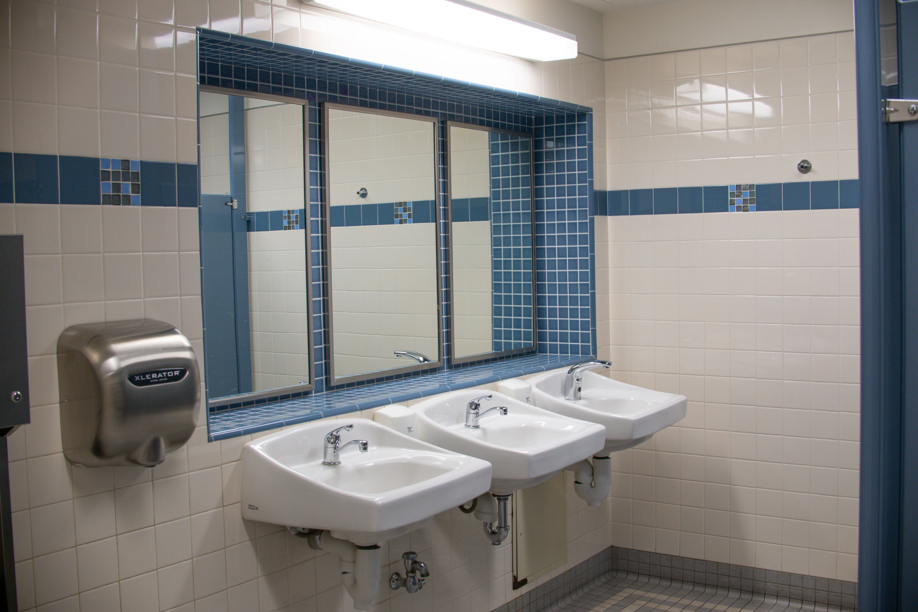 Clean, tiled commercial restroom with sinks and mirrors